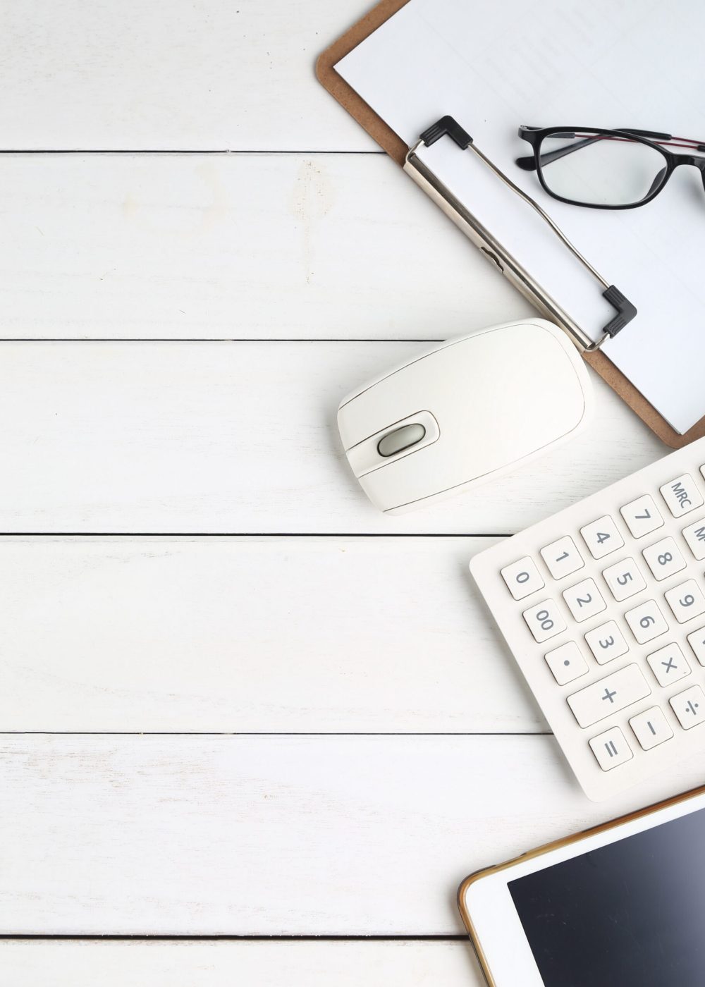 Services glasses, calculator and tablet on white neat desk